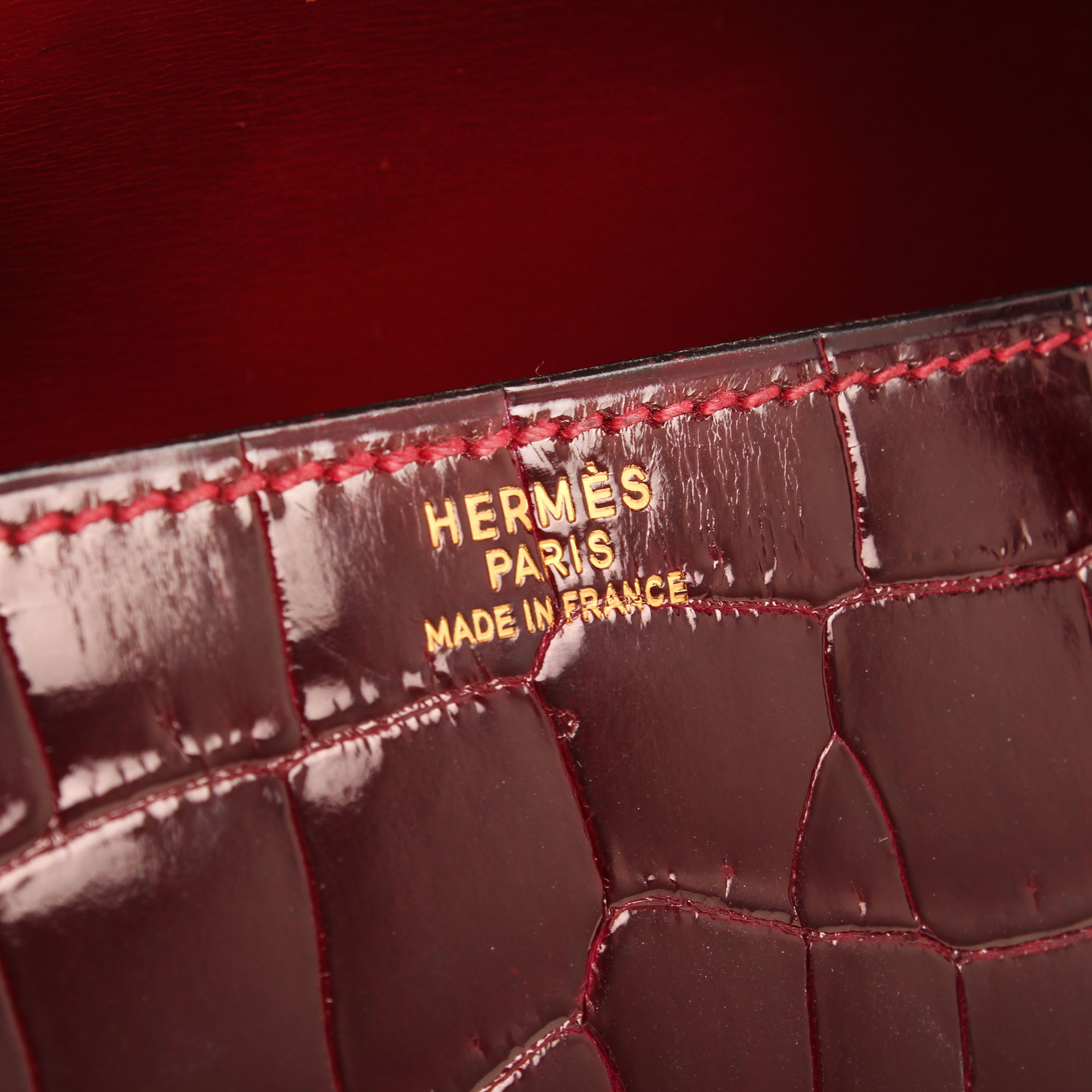 Imagen del a firma del bolso hermes drag vintage cocodrilo poroso color frambuesa